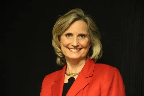 Headshot of Nancy Wilson, CEO of Morrison Container Handling Solutions. Nancy is wearing a red jacket and there is a black background behind the image.