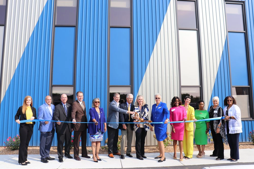 Elected officials and Morrison leadership cut a ribbon outside the new Morrison building.